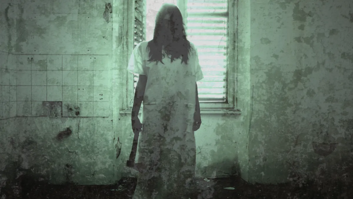Asylum Patient Standing in Old Room Holding an Axe